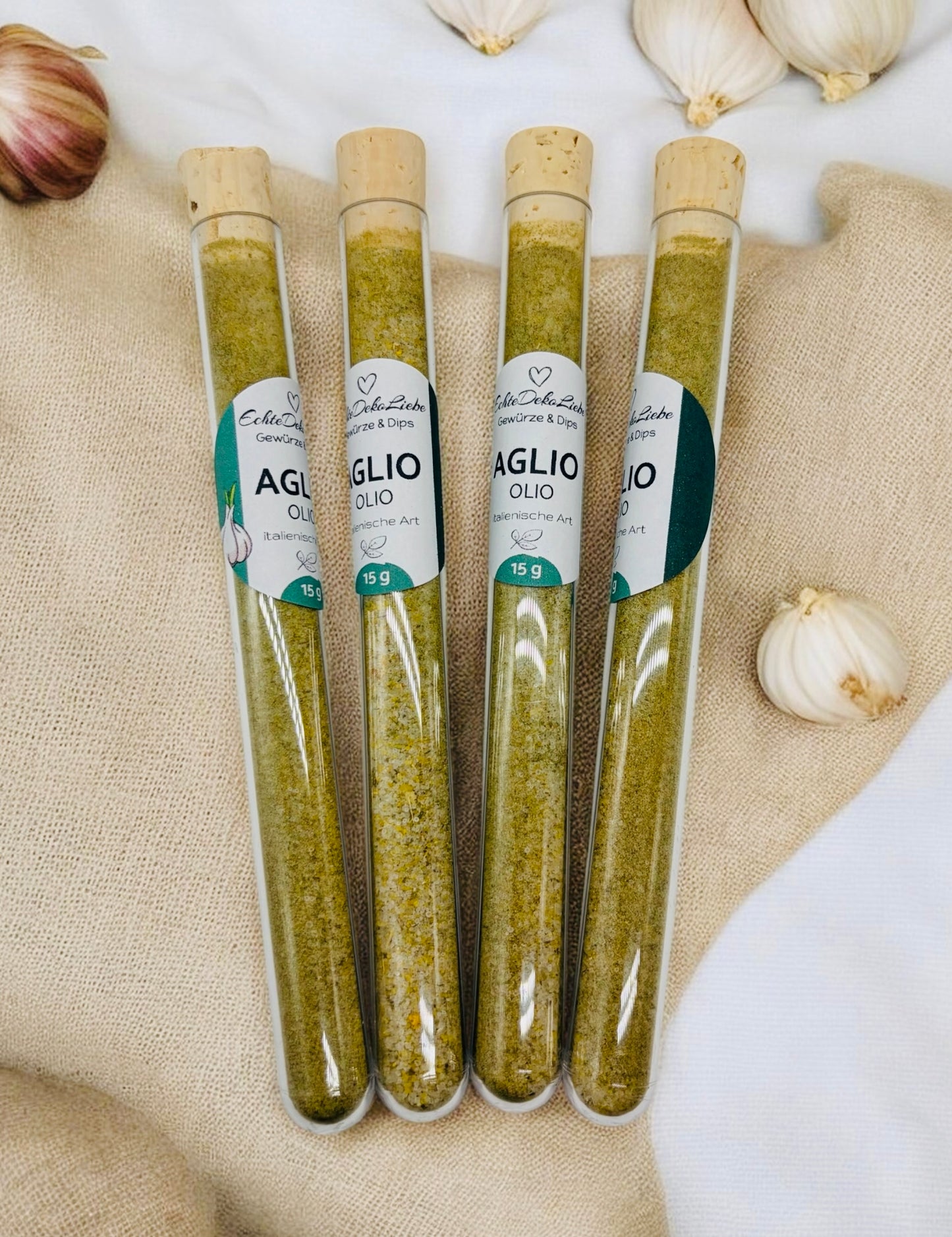 Sieben Reagenzgläser mit Naturkorken, gefüllt mit verschiedenen Gewürzen und Salzen. Zu sehen sind Rühreigewürz, Kräutersalz, Himalayasalz, Pommesgewürz, Aglio-Olio-Gewürz, vergoldeter Pfeffer und vergoldetes Salz. Die Gläser tragen moderne weiße Etiketten mit Produktname und Füllmenge. Arrangiert auf hellem Holzhintergrund mit dekorativen Trockenblumen – eine besondere Geschenkidee für Gewürzliebhaber.