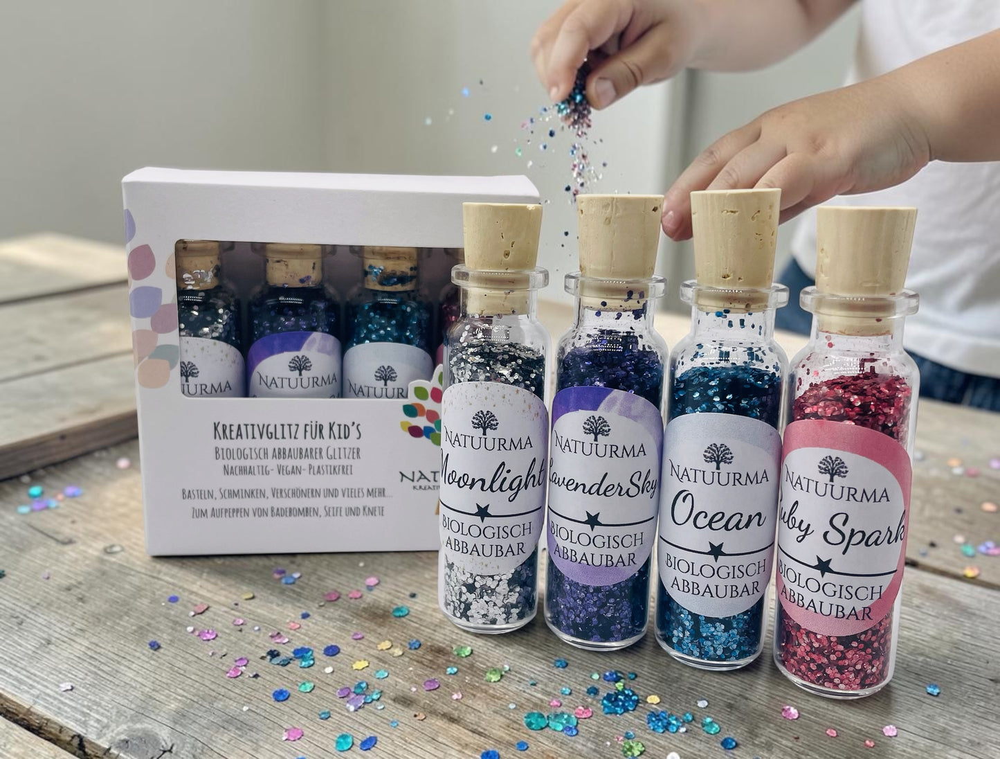 Das Bild zeigt unser hochwertiges KreativGlitzer-Set mit vier Glasfläschchen aus Glas und Naturkorken. Enthalten sind die Farben Silber, Blau, Lila und Rot. Der biologisch abbaubare Glitzer ist plastikfrei, vegan und Made in Germany. Ideal für Bastelarbeiten, DIY-Projekte, Sensorik, Matschküchen, Dekorationen, Grußkarten, Geschenkverpackungen und viele weitere kreative Ideen. Liebevoll verpackt von Echte DekoLiebe.