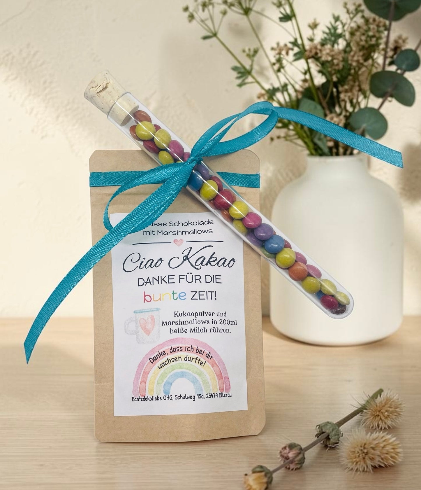 Liebevoll gestaltetes Abschiedsgeschenk mit heißer Schokolade und Marshmallows im Kraftpapierbeutel. Das Etikett „Ciao Kakao – Danke für die bunte Zeit!“ wird durch einen farbenfrohen Regenbogen mit dem Spruch „Danke, dass du mich hast wachsen lassen.“ ergänzt. Perfekt als kleines Dankeschön für Erzieherinnen, Lehrer oder Tagesmütter. Optional mit Reagenzglas voller bunter Schokolinsen als süße Aufmerksamkeit.