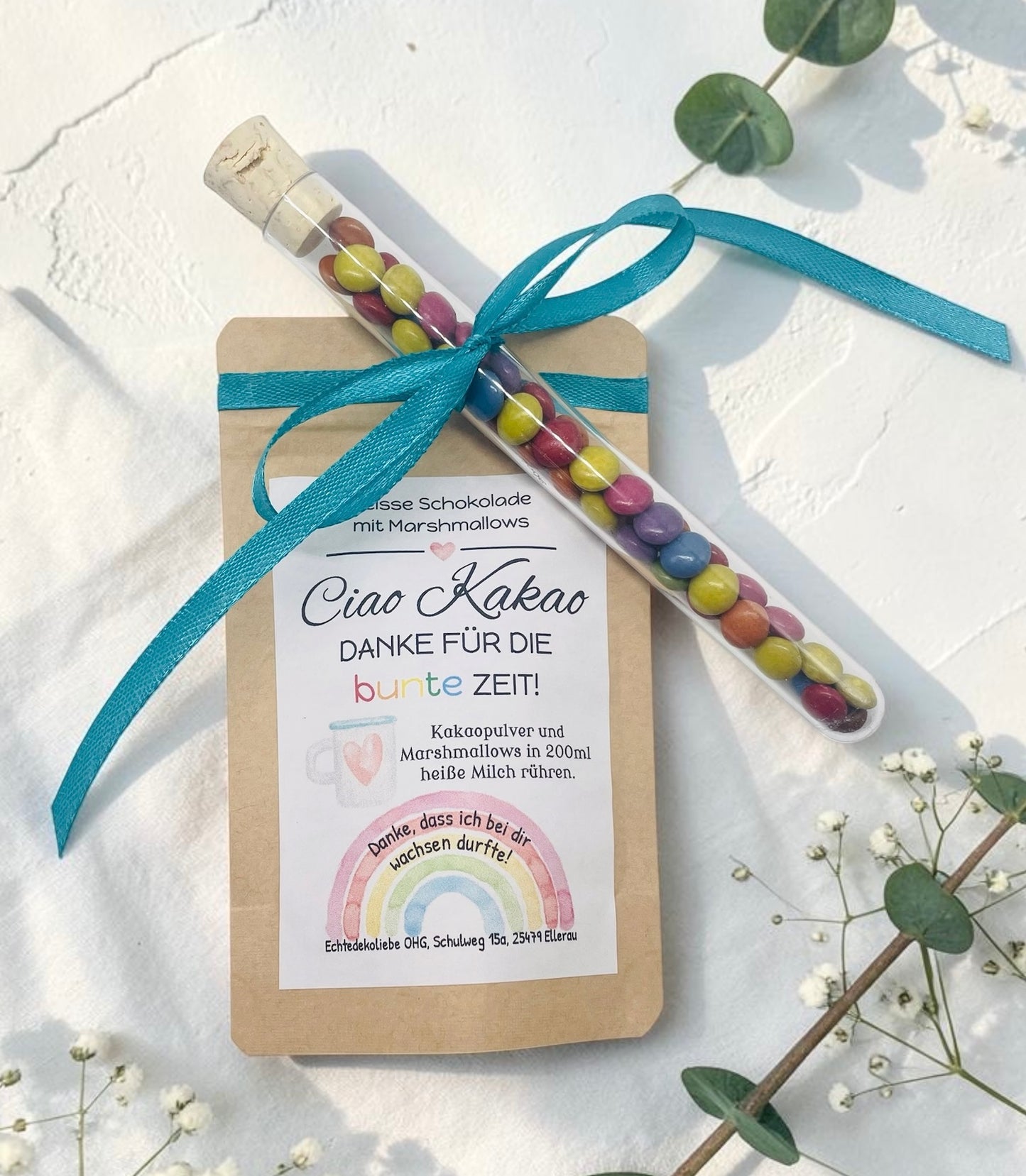 Liebevoll gestaltetes Abschiedsgeschenk mit heißer Schokolade und Marshmallows im Kraftpapierbeutel. Das Etikett „Ciao Kakao – Danke für die bunte Zeit!“ wird durch einen farbenfrohen Regenbogen mit dem Spruch „Danke, dass du mich hast wachsen lassen.“ ergänzt. Perfekt als kleines Dankeschön für Erzieherinnen, Lehrer oder Tagesmütter. Optional mit Reagenzglas voller bunter Schokolinsen als süße Aufmerksamkeit.