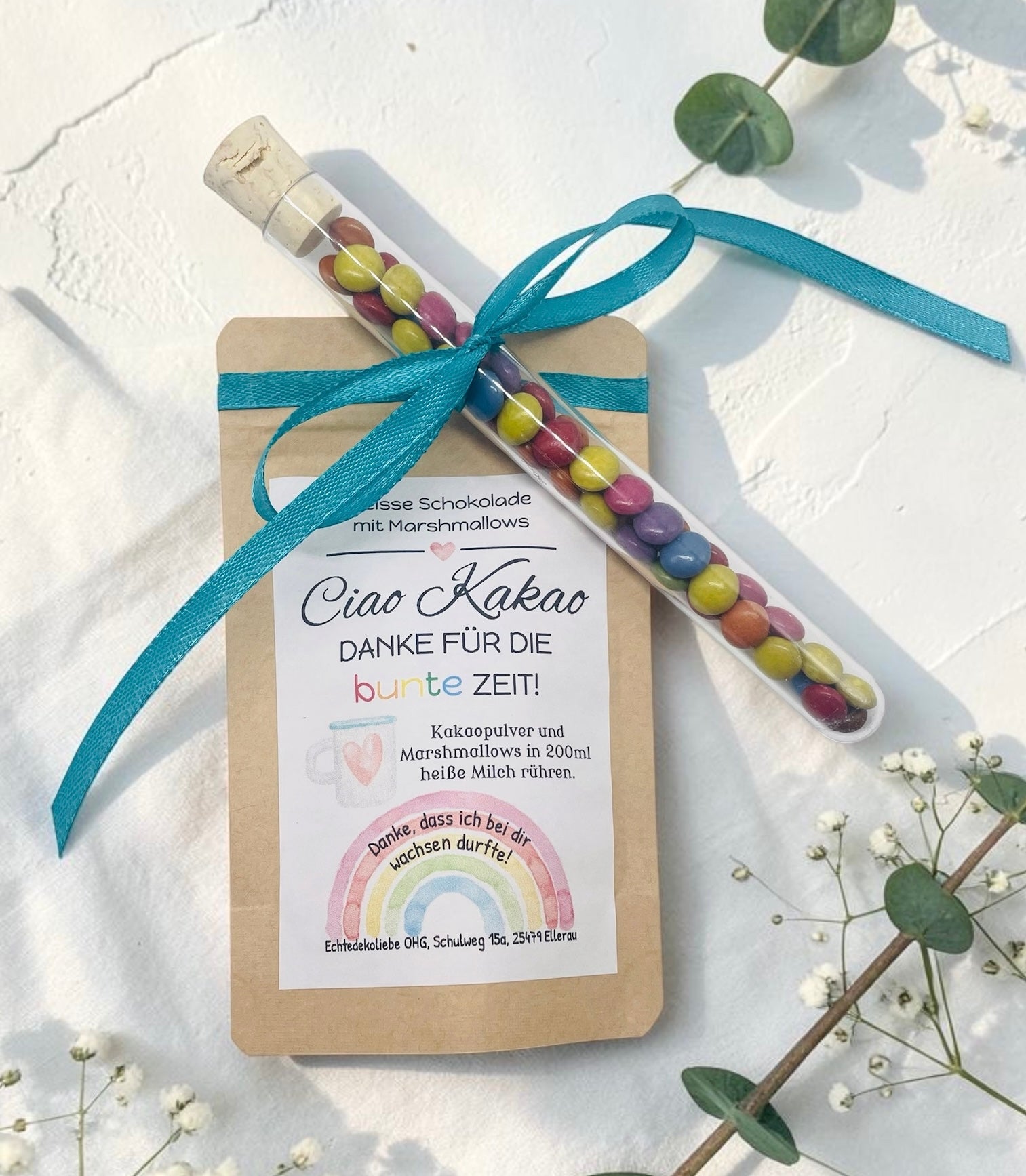 Liebevoll gestaltetes Abschiedsgeschenk mit heißer Schokolade und Marshmallows im Kraftpapierbeutel. Das Etikett „Ciao Kakao – Danke für die bunte Zeit!“ wird durch einen farbenfrohen Regenbogen mit dem Spruch „Danke, dass du mich hast wachsen lassen.“ ergänzt. Perfekt als kleines Dankeschön für Erzieherinnen, Lehrer oder Tagesmütter. Optional mit Reagenzglas voller bunter Schokolinsen als süße Aufmerksamkeit.