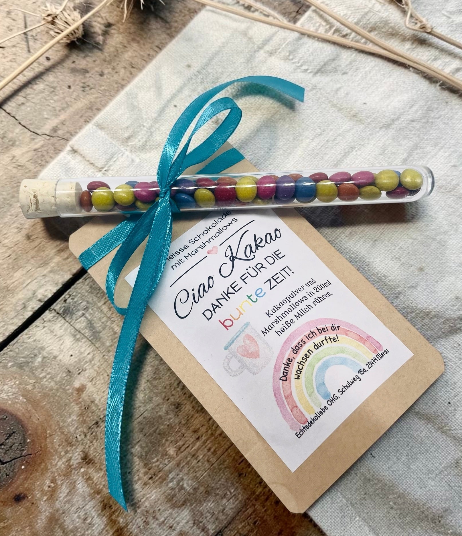 Liebevoll gestaltetes Abschiedsgeschenk mit heißer Schokolade und Marshmallows im Kraftpapierbeutel. Das Etikett „Ciao Kakao – Danke für die bunte Zeit!“ wird durch einen farbenfrohen Regenbogen mit dem Spruch „Danke, dass du mich hast wachsen lassen.“ ergänzt. Perfekt als kleines Dankeschön für Erzieherinnen, Lehrer oder Tagesmütter. Optional mit Reagenzglas voller bunter Schokolinsen als süße Aufmerksamkeit.