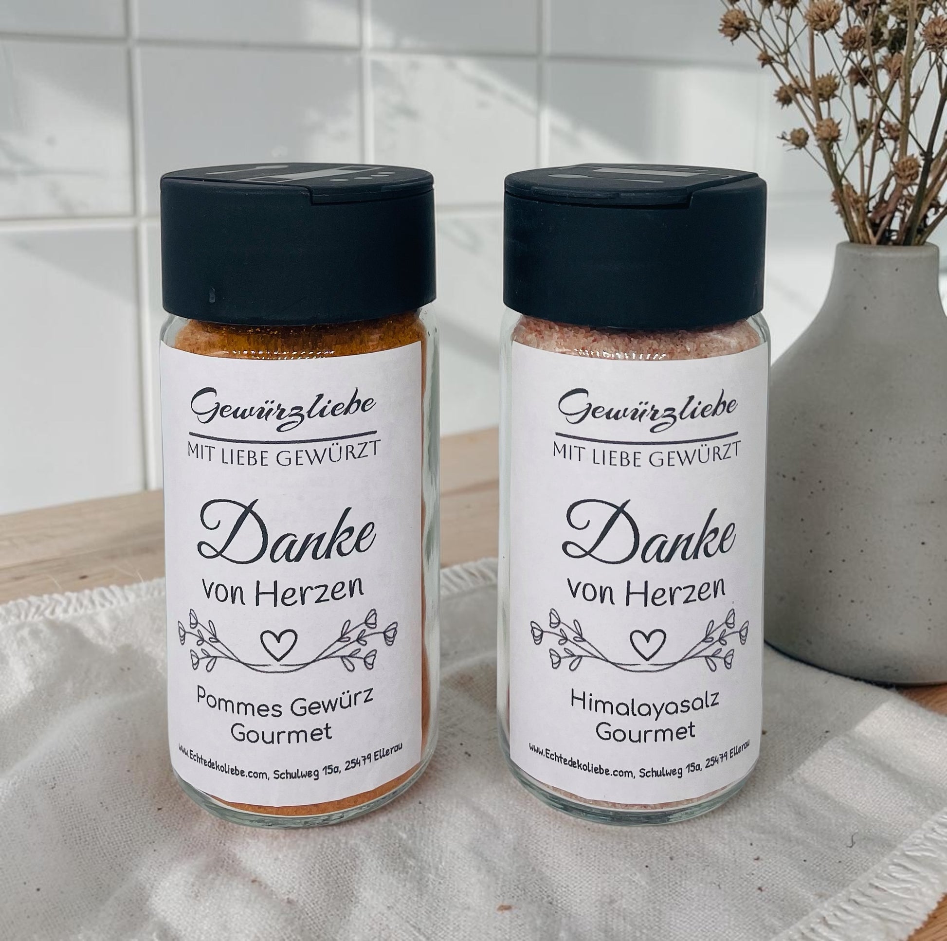 Modernes Gewürzglas aus Klarglas mit schwarzem Streudeckel, gefüllt mit rosa Himalayasalz. Das weiße Etikett trägt den Schriftzug „Gewürzliebe – Mit Liebe gewürzt“ sowie die Botschaft „Danke von Herzen“ in eleganter schwarzer Schrift. Eine filigrane florale Illustration mit Herz verziert das Design. Das Glas eignet sich als liebevolles Dankeschön, Gastgeschenk zur Hochzeit, Mitbringsel, Geburtstagsgeschenk oder kleine Aufmerksamkeit und ist auf Wunsch personalisierbar.
