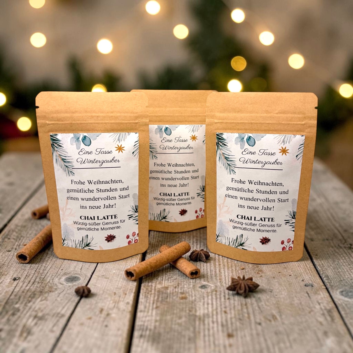 Braune Kraftpapiertüten mit weihnachtlichem Design stehen dekorativ auf einem rustikalen Holztisch. Die Tüten sind mit einem winterlich gestalteten Etikett versehen und enthalten eine Getränkemischung bzw. ein Heißgetränk zum Genießen. Im Hintergrund sorgen Tannenzweige, warme Lichter und weihnachtliche Dekoration für eine gemütliche Adventsstimmung.