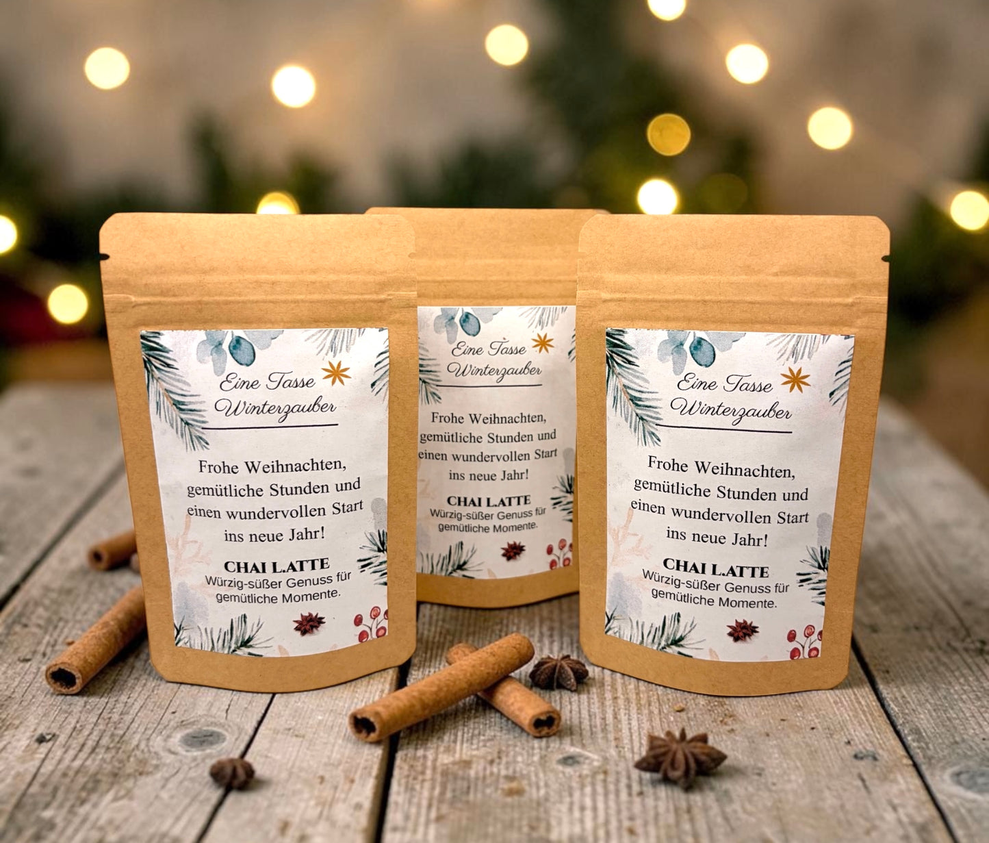 Braune Kraftpapiertüten mit weihnachtlichem Design stehen dekorativ auf einem rustikalen Holztisch. Die Tüten sind mit einem winterlich gestalteten Etikett versehen und enthalten eine Getränkemischung bzw. ein Heißgetränk zum Genießen. Im Hintergrund sorgen Tannenzweige, warme Lichter und weihnachtliche Dekoration für eine gemütliche Adventsstimmung.