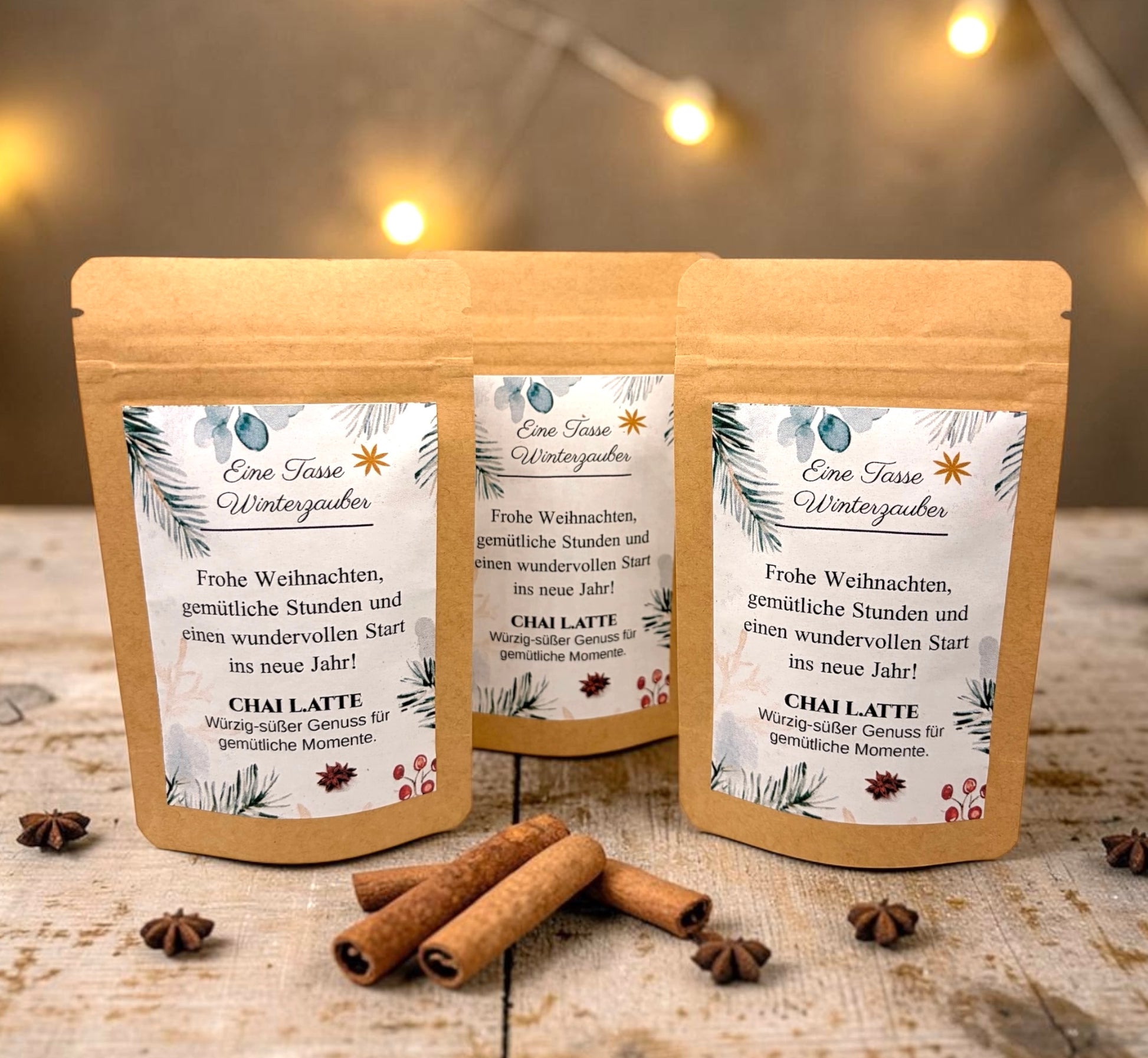 Braune Kraftpapiertüten mit weihnachtlichem Design stehen dekorativ auf einem rustikalen Holztisch. Die Tüten sind mit einem winterlich gestalteten Etikett versehen und enthalten eine Getränkemischung bzw. ein Heißgetränk zum Genießen. Im Hintergrund sorgen Tannenzweige, warme Lichter und weihnachtliche Dekoration für eine gemütliche Adventsstimmung.