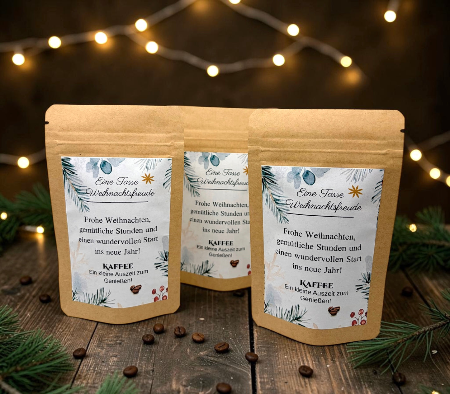 Braune Kraftpapiertüten mit weihnachtlichem Design stehen dekorativ auf einem rustikalen Holztisch. Die Tüten sind mit einem winterlich gestalteten Etikett versehen und enthalten eine Getränkemischung bzw. ein Heißgetränk zum Genießen. Im Hintergrund sorgen Tannenzweige, warme Lichter und weihnachtliche Dekoration für eine gemütliche Adventsstimmung.