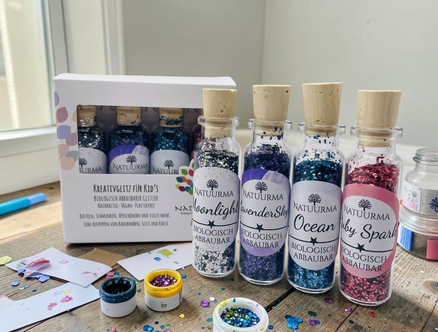 Das Bild zeigt unser hochwertiges KreativGlitzer-Set mit vier Glasfläschchen aus Glas und Naturkorken. Enthalten sind die Farben Silber, Blau, Lila und Rot. Der biologisch abbaubare Glitzer ist plastikfrei, vegan und Made in Germany. Ideal für Bastelarbeiten, DIY-Projekte, Sensorik, Matschküchen, Dekorationen, Grußkarten, Geschenkverpackungen und viele weitere kreative Ideen. Liebevoll verpackt von Echte DekoLiebe.